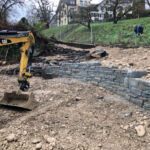 Hinter der Mauer werden mit grösseren Steinen weitere Strukturen erstellt.